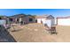 Large backyard with stone pathway, seating around a firepit, storage shed, grill, dining set and swing set at 1950 E Dust Devil Dr, San Tan Valley, AZ 85143