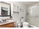 Well-lit bathroom with a framed mirror, vanity with sink, toilet, and glass-enclosed shower at 1950 E Dust Devil Dr, San Tan Valley, AZ 85143