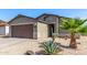 Exterior of the house showcasing its well-maintained front yard with desert landscaping and a two-car garage at 1950 E Dust Devil Dr, San Tan Valley, AZ 85143