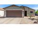Charming home showcasing a well-manicured desert landscape, complemented by a spacious two-car garage at 1950 E Dust Devil Dr, San Tan Valley, AZ 85143