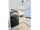 A kitchen with black stainless appliances, white cabinetry and wood-look flooring at 1950 E Dust Devil Dr, San Tan Valley, AZ 85143