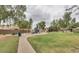 Neighborhood park featuring colorful playground equipment, lush green space, and mature shade trees at 1950 E Dust Devil Dr, San Tan Valley, AZ 85143