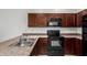 Up close kitchen view featuring dark wood cabinetry and black appliances at 1950 N Center St # 115, Mesa, AZ 85201