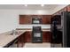 Up close kitchen view featuring dark wood cabinetry and black appliances at 1950 N Center St # 115, Mesa, AZ 85201