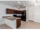 Kitchen featuring dark wood cabinetry, black appliances, and a breakfast bar at 1950 N Center St # 115, Mesa, AZ 85201