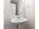 Bright powder room features a pedestal sink, silver hardware and a round mirror at 1950 N Center St # 115, Mesa, AZ 85201