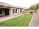 Lush backyard features green grass, rock landscaping, and covered patio with grill at 19814 W Buchanan St, Buckeye, AZ 85326