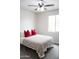 Bright bedroom with neutral colored walls, ceiling fan, and plush gray carpet at 19814 W Buchanan St, Buckeye, AZ 85326