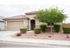 Well-maintained single-story home with desert landscaping, shrubs, and a two-car garage at 19814 W Buchanan St, Buckeye, AZ 85326
