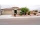 Charming single-story home featuring a terracotta tile roof, a two-car garage, and manicured landscaping at 19814 W Buchanan St, Buckeye, AZ 85326