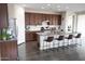Spacious kitchen featuring dark wood cabinetry, granite countertops, and an island with bar seating at 19814 W Buchanan St, Buckeye, AZ 85326