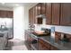Modern kitchen featuring stainless steel appliances, dark wood cabinets, and granite countertops with white backsplash at 19814 W Buchanan St, Buckeye, AZ 85326