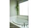 Close up of white soaking tub under window in bright bathroom at 19814 W Buchanan St, Buckeye, AZ 85326