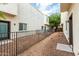View of a gated backyard with rock landscaping, exterior building, and trees at 2000 N 36Th St # 29, Phoenix, AZ 85008