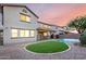 Exterior view of backyard featuring pool, artificial turf, and gravel landscaping at 21472 E Saddle Ct, Queen Creek, AZ 85142