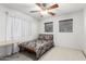Bedroom with ceiling fan, light wood floors, and large windows at 21472 E Saddle Ct, Queen Creek, AZ 85142