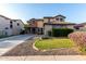 Beautiful two-story home featuring a lush green lawn, stone accents, and a spacious driveway at 21472 E Saddle Ct, Queen Creek, AZ 85142