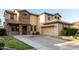 Inviting two-story home showcasing a two-car garage and stone accents around the entry and windows at 21472 E Saddle Ct, Queen Creek, AZ 85142