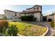 Well-maintained front yard with green lawn and mature landscaping, complemented by the home's design at 21472 E Saddle Ct, Queen Creek, AZ 85142
