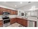 Spacious kitchen with stainless steel appliances, wood cabinetry, and an open view to the living area at 21472 E Saddle Ct, Queen Creek, AZ 85142