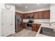 Well-equipped kitchen features stainless steel appliances, wood cabinets, tile flooring, and ample counter space at 21472 E Saddle Ct, Queen Creek, AZ 85142