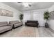 Bright living room featuring neutral-toned sofas, light wood floors, and sheer curtains for natural light at 21472 E Saddle Ct, Queen Creek, AZ 85142