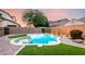 Backyard showcasing a pool with synthetic lawn and well-maintained desert landscaping at 21472 E Saddle Ct, Queen Creek, AZ 85142