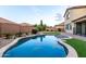 Backyard features a uniquely shaped pool surrounded by lush landscaping and mature trees at 21472 E Saddle Ct, Queen Creek, AZ 85142