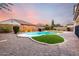 Backyard pool with pebble landscaping, turf, and block wall fence at 21472 E Saddle Ct, Queen Creek, AZ 85142