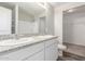Bathroom featuring dual sinks with granite countertops and white cabinets, plus a walk-in closet at 255 W Dewey Ave, Coolidge, AZ 85128