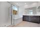 Modern bathroom features a glass-enclosed shower, soaking tub, and dual sink vanity at 25616 N 148Th Dr, Surprise, AZ 85387