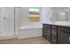 Bathroom featuring separate shower, soaking tub, and dark-stained cabinets with double sinks at 25616 N 148Th Dr, Surprise, AZ 85387