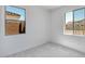 Light and airy bedroom with gray carpet and two windows offering views of the neighborhood at 25616 N 148Th Dr, Surprise, AZ 85387