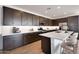 Modern kitchen features stainless appliances, large island with seating and stylish backsplash at 25616 N 148Th Dr, Surprise, AZ 85387