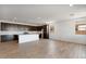Open-concept kitchen with dark wood cabinets, island, and stainless steel appliances adjacent to living area at 25616 N 148Th Dr, Surprise, AZ 85387