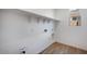 Bright laundry room with hardwood floors, and open shelves for organized storage at 25616 N 148Th Dr, Surprise, AZ 85387