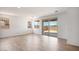Bright, empty living room featuring wood-look tile floors and a sliding glass door to the backyard at 25616 N 148Th Dr, Surprise, AZ 85387