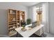 Bright home office with large window, modern desk and shelving unit for storage at 25616 N 148Th Dr, Surprise, AZ 85387