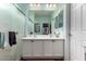 Bathroom with a double vanity and sinks and a glass enclosed shower in soft, light-colored tones at 26145 W Runion Dr, Buckeye, AZ 85396