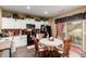 Eat-in kitchen features white cabinets, black appliances and a round table with wooden chairs, great for a cozy meal at 26145 W Runion Dr, Buckeye, AZ 85396