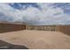 Desert backyard featuring a brick wall and metal gate with mountain views under a partly cloudy sky at 2823 N 212Th Dr, Buckeye, AZ 85396