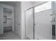 Bathroom showcasing a modern shower with glass door and tile flooring, plus access to a walk-in closet at 2823 N 212Th Dr, Buckeye, AZ 85396