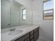Well-lit bathroom vanity featuring a quartz countertop, stylish cabinetry, and a large mirror at 2823 N 212Th Dr, Buckeye, AZ 85396