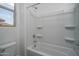 Bathroom showcasing a tiled shower and bath combination with built-in shelving and bright natural light at 2823 N 212Th Dr, Buckeye, AZ 85396