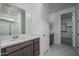 Bright bathroom featuring a quartz countertop, stylish cabinetry, and a large, well-lit mirror at 2823 N 212Th Dr, Buckeye, AZ 85396
