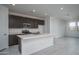 Modern kitchen with stainless steel appliances, a large island with a sink, and sleek, dark-stained cabinets at 2823 N 212Th Dr, Buckeye, AZ 85396