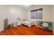 Bedroom featuring a window, modern ceiling fan, and wood-look floors at 288 W Los Alamos St, Gilbert, AZ 85233