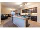 Open concept kitchen with granite countertops, stainless appliances, island with seating, tile floor, and a cozy living room at 288 W Los Alamos St, Gilbert, AZ 85233