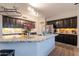 Close up on a kitchen island with granite countertops, stainless steel faucet and dark cabinets in a large open kitchen at 288 W Los Alamos St, Gilbert, AZ 85233