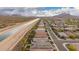 Extensive scenic aerial view of a residential neighborhood with mountain views and irrigation canal at 28931 N 64Th Dr, Phoenix, AZ 85083